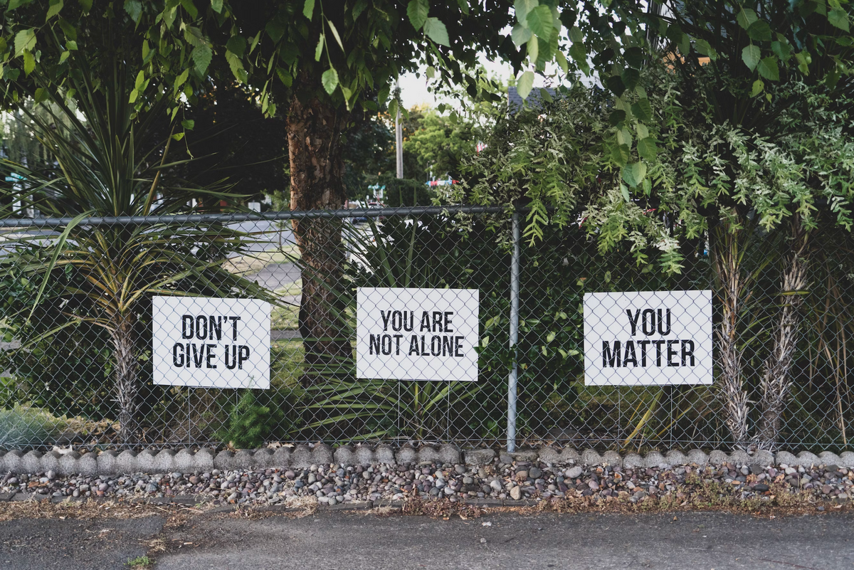 Supportive messages on a fence, emphasizing the benefits of kratom for managing opiate addiction.